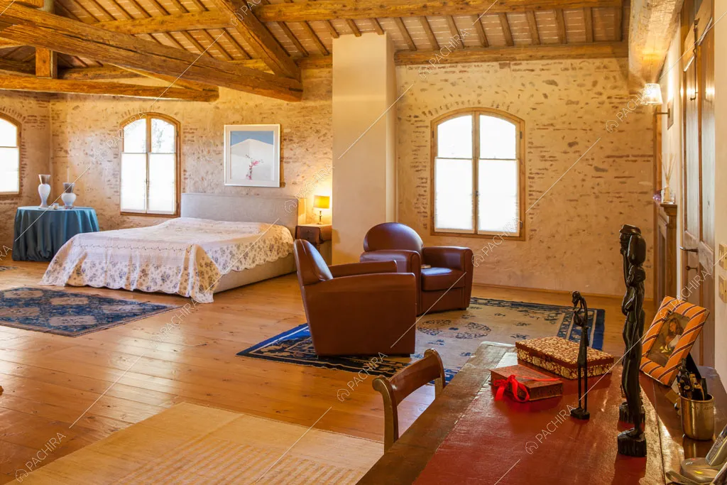 Pavimento in parquet nella camera da letto matrimoniale con pareti in mattoncini a vista