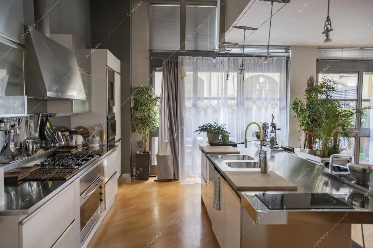 Luminosa cucina a isola con fornelli a induzione e a gas e pavimento in parquet