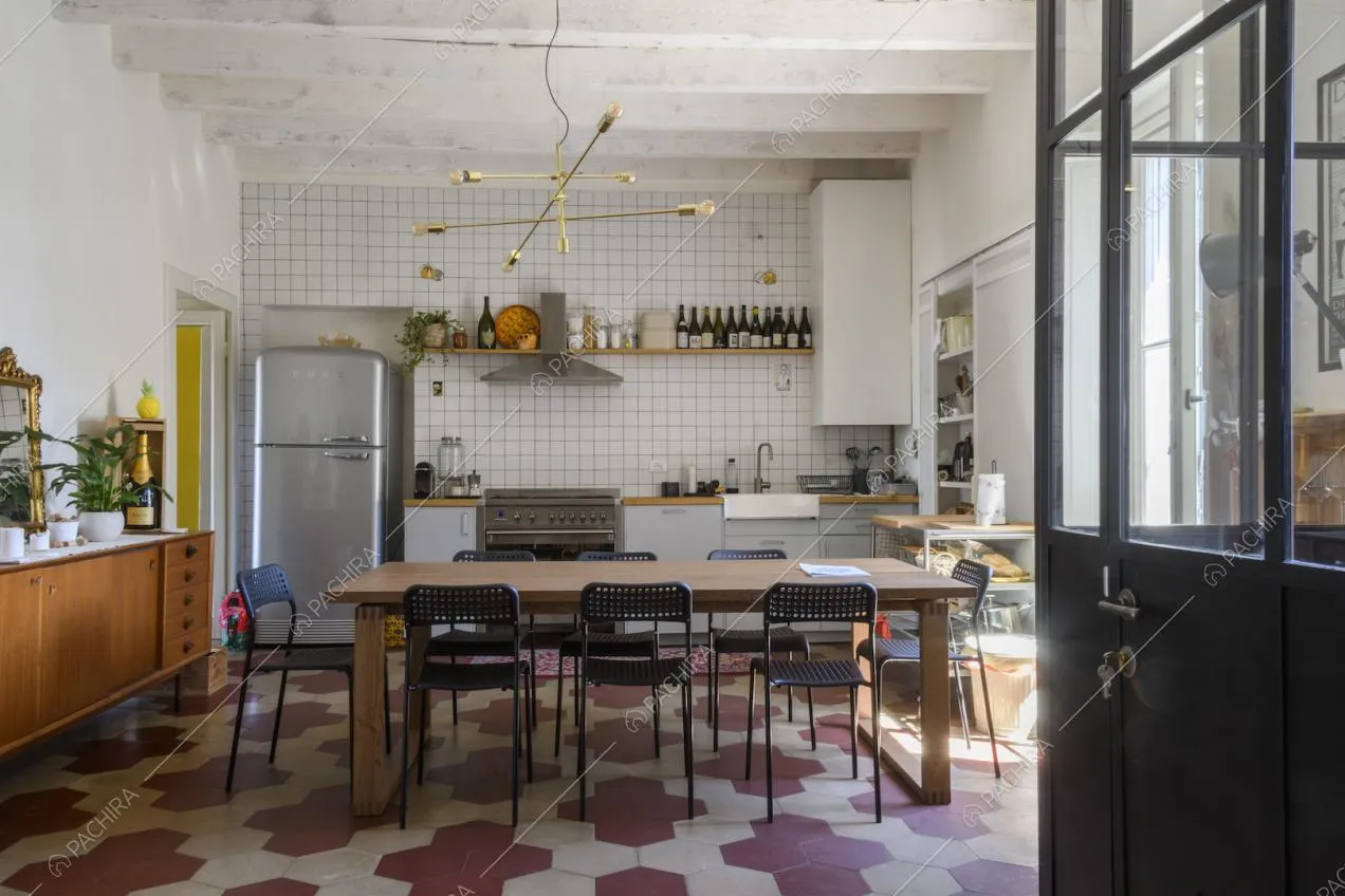 Travi a vista nella cucina e parete rivestita con piastrelle