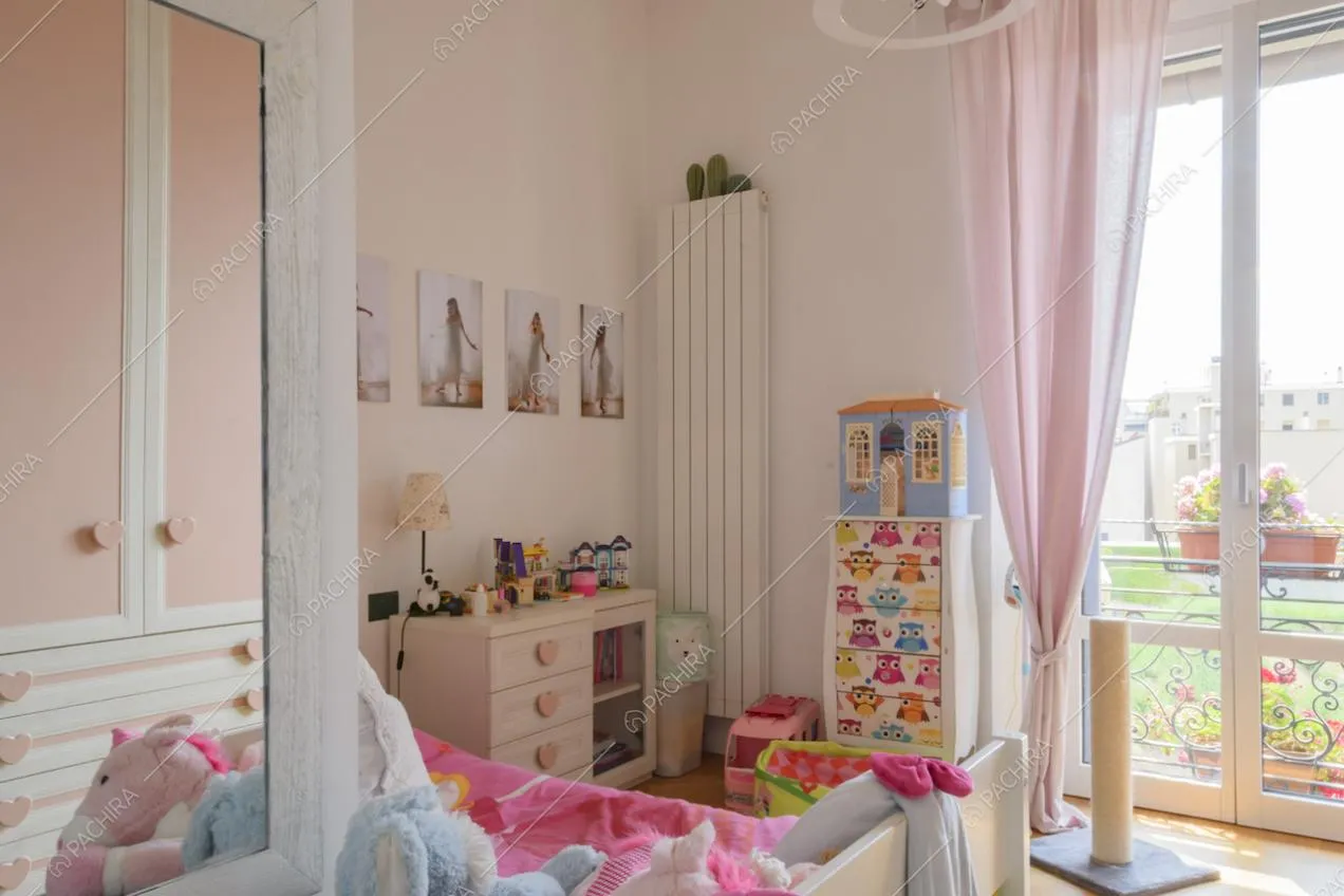 Cameretta con arredi color rosa e porta finestra