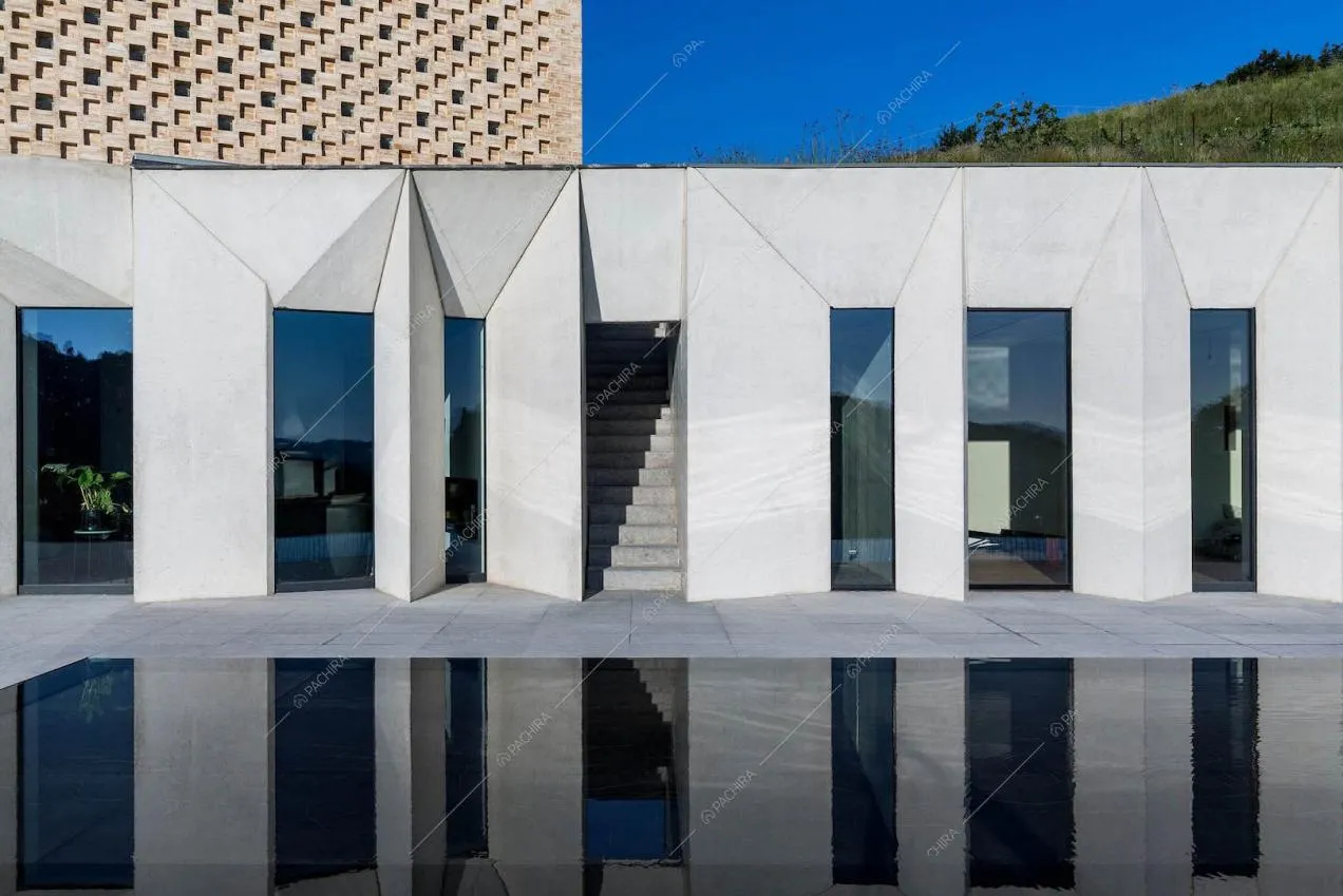 Vista sugli esterni bianchi, sulle vetrate e sulle scale di ingresso della villa
