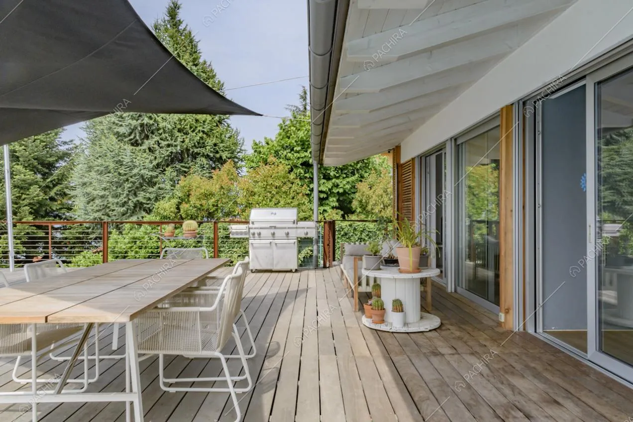 Sulla terrazza con pavimento in parquet da esterni, ecco un meraviglioso tavolo da pranzo in legno