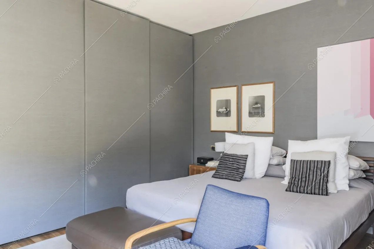 Armadio moderno color grigio vicino al letto matrimoniale