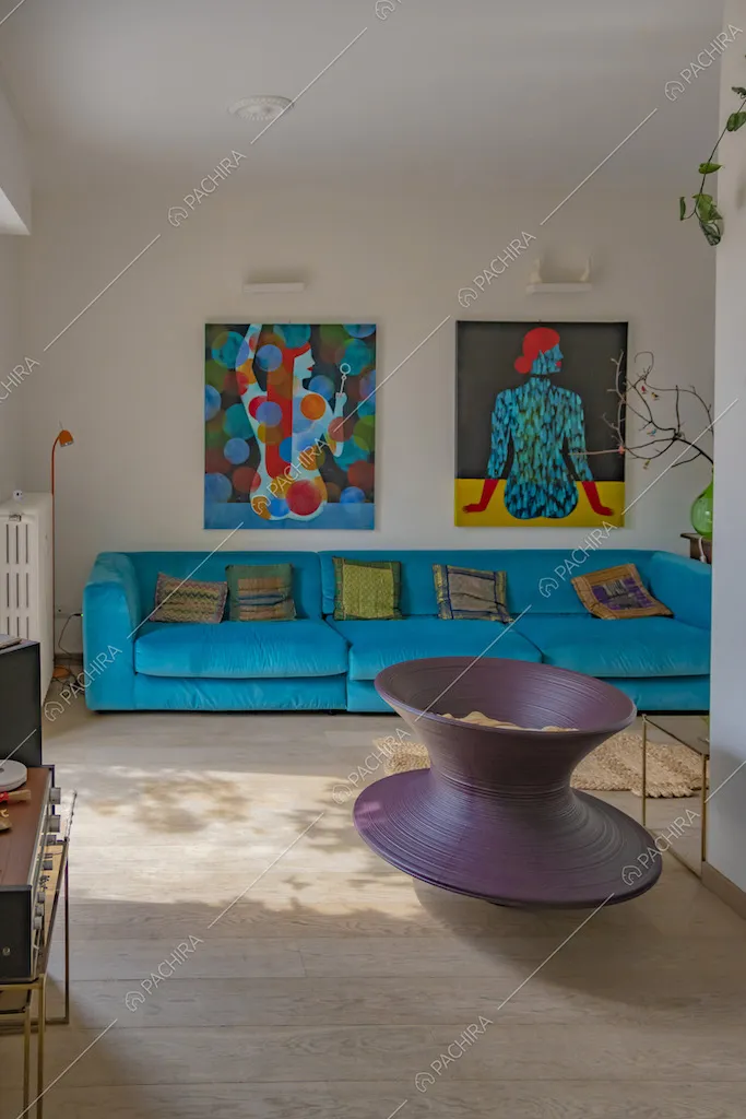 Soggiorno con divano azzurro e quadri in stile contemporaneo