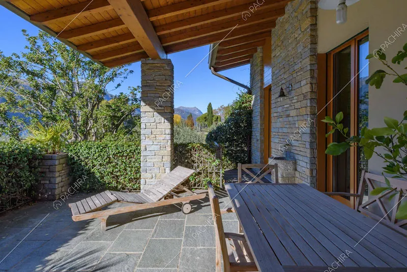 Portico con tavolo da pranzo in legno e soffitto in travi in legno a vista