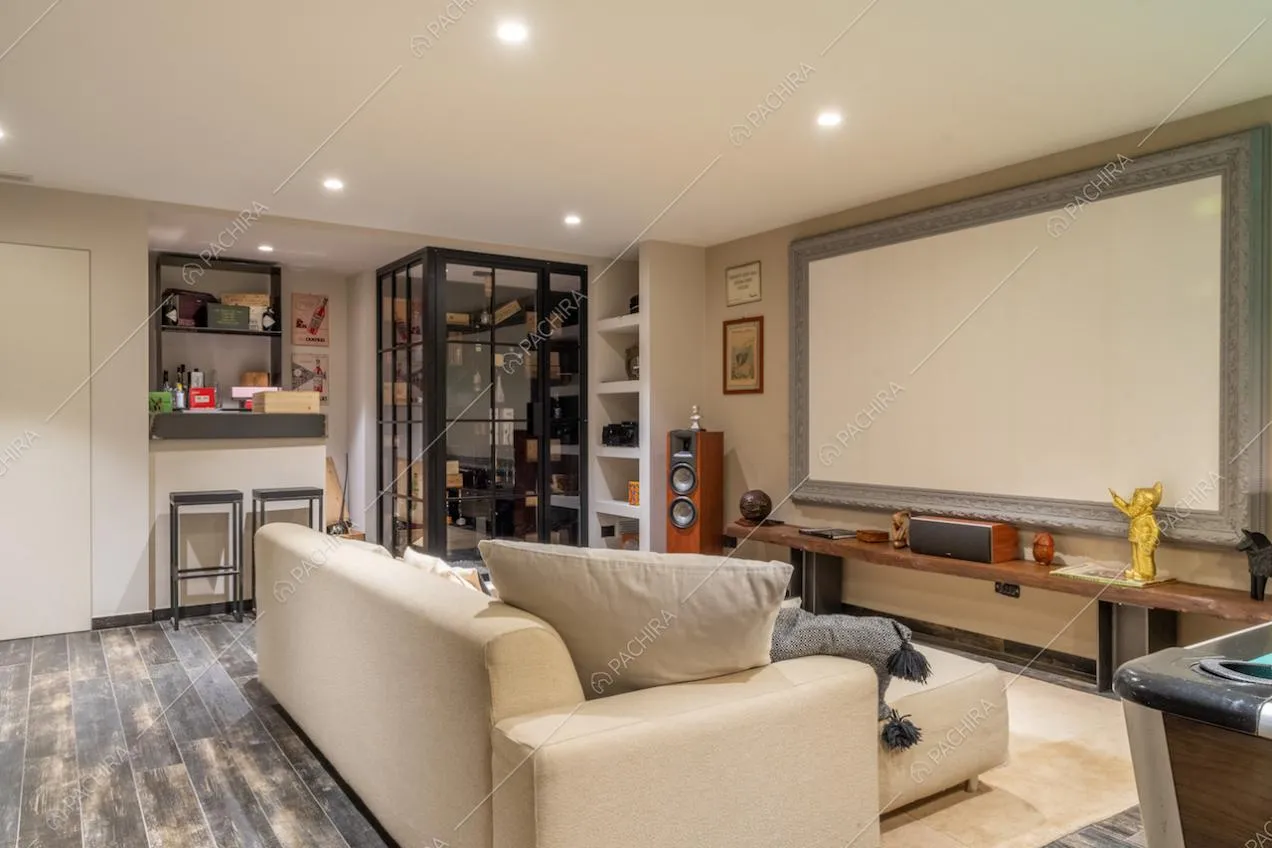 Divano bianco nella sala hobby dal pavimento in parquet con grande schermo