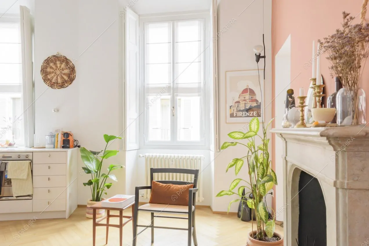 Salotto con camino, cucina a vista e parquet a spina di pesce