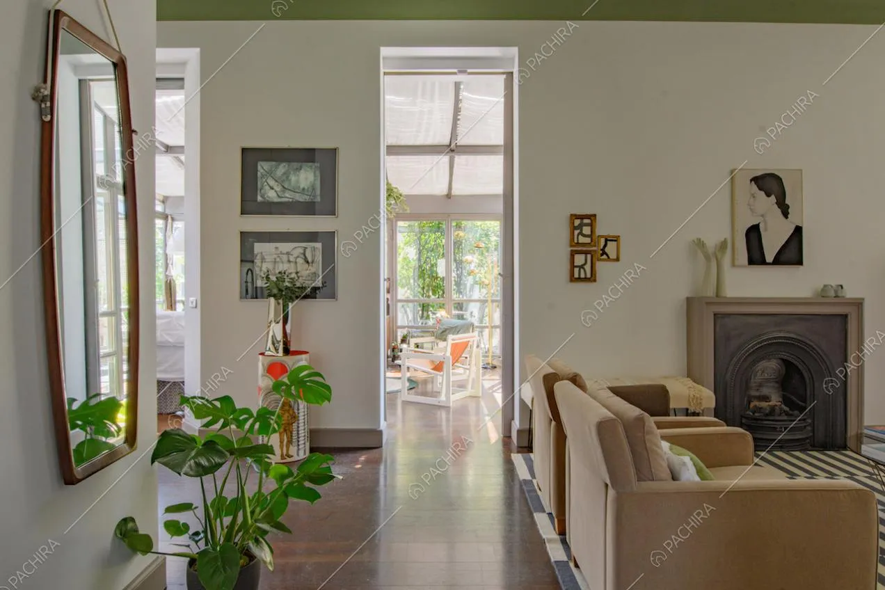 Pavimento in parquet nella zona living con camino, poltrone e vista sulla veranda