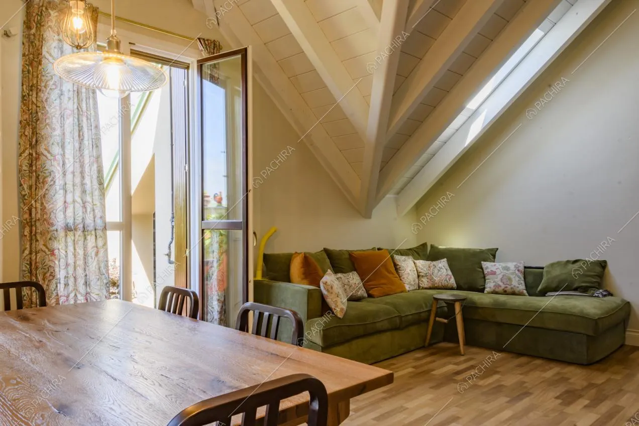 Angolo del soggiorno con divano colorato e tavolo in legno