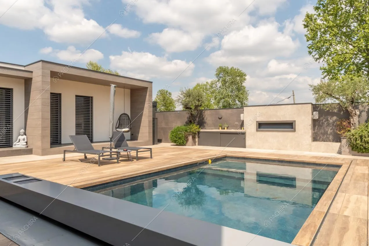 Piscina della location, lettini neri e veranda con poltrona sospesa