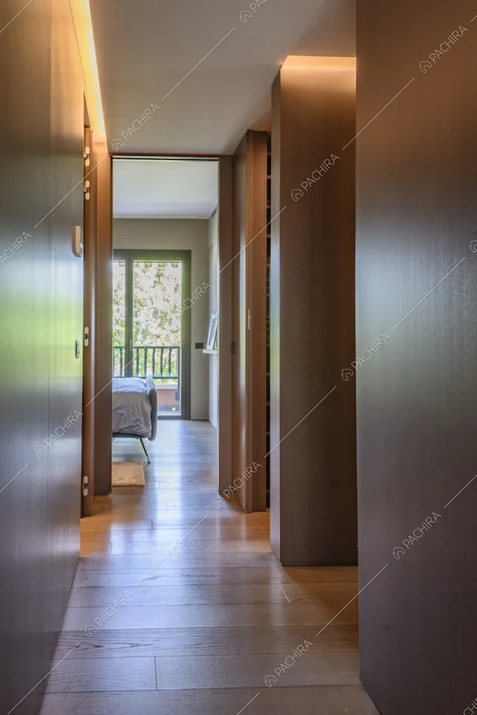 Corridoio con pareti in legno lucidato e parquet