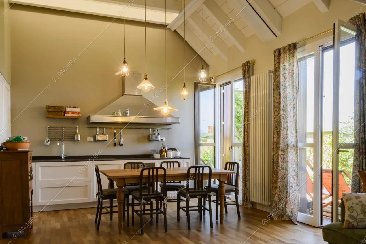 Open space con cucina a parete e tavolo da pranzo con sedie