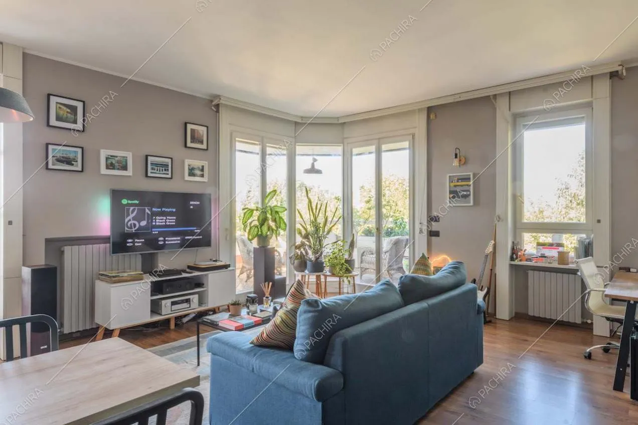 Pareti grigie nella zona living con pavimento in parquet e divano blu