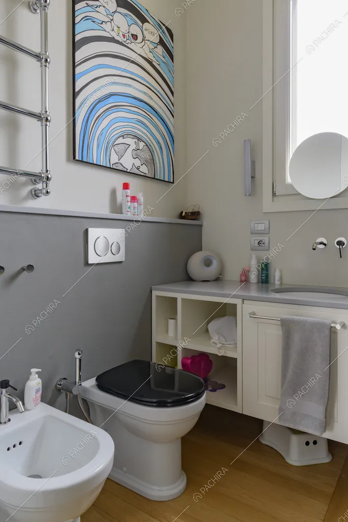 Bagno con pavimento in parquet e parete grigia e bianca