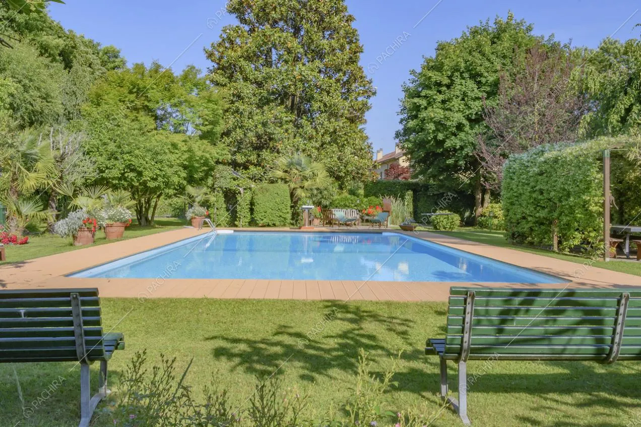 Panchine all'ombra lungo il bordo della piscina