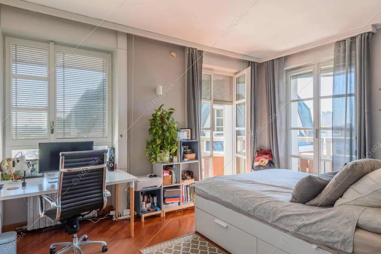 Camera da letto con scrivania, pavimento in parquet e porta-finestra