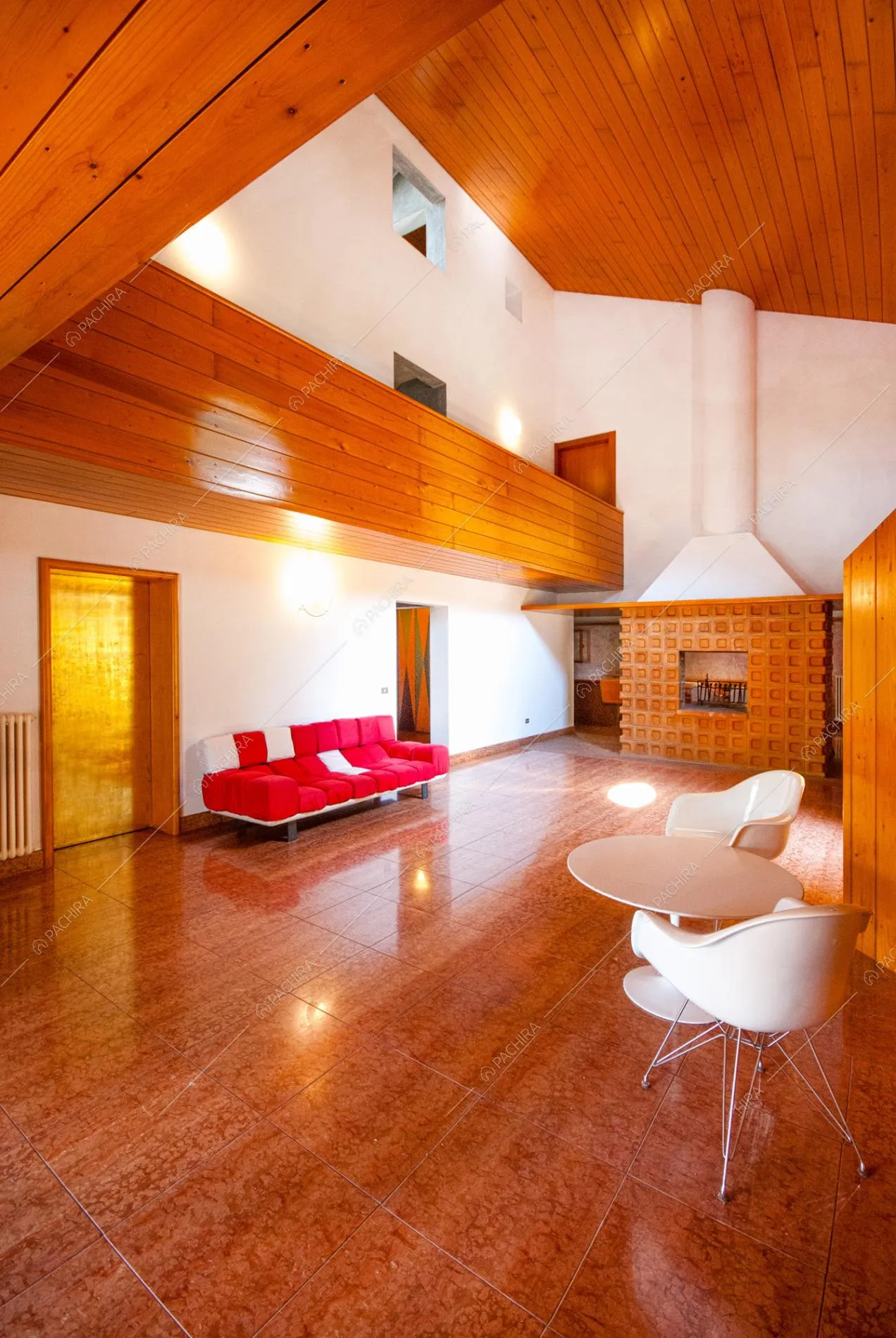 Camino, divano moderno e sedie bianche su pavimento in cotto