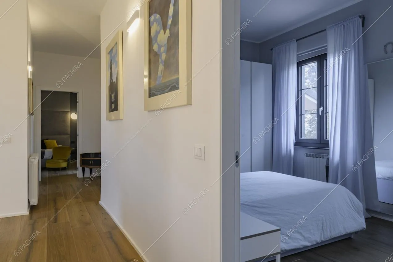 Scorcio sulla camera da letto e quadri appesi alle pareti del corridoio