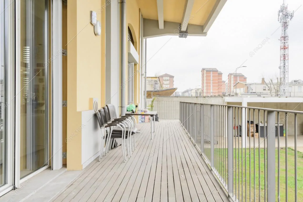 Balcone con pavimento in parquet, porte-finestre ed esterni gialli della Location