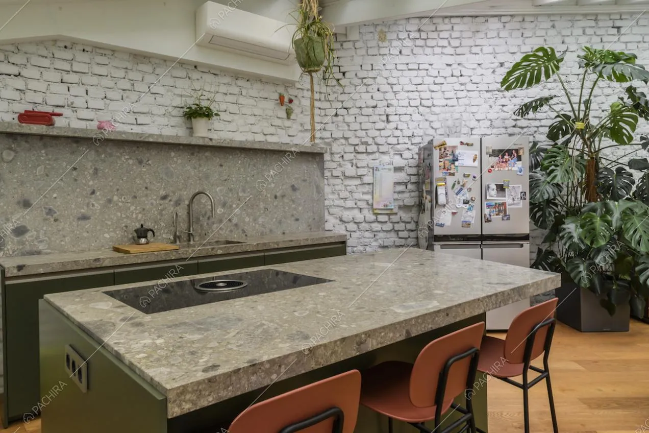 Cucina di design a isola e muro in mattoni a vista bianchi
