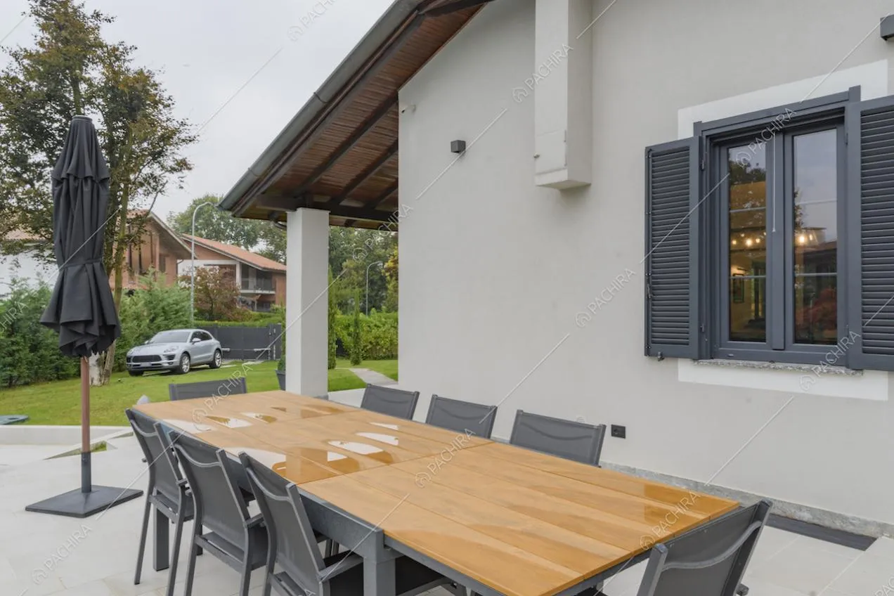 Area pranzo esterna alla villa con tavolo, sedie e ombrellone