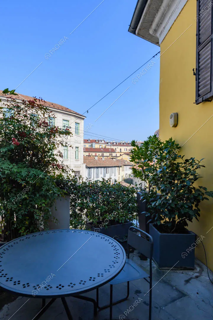 Terrazza con tavolo da pranzo e sedie da esterni e vista sulla città