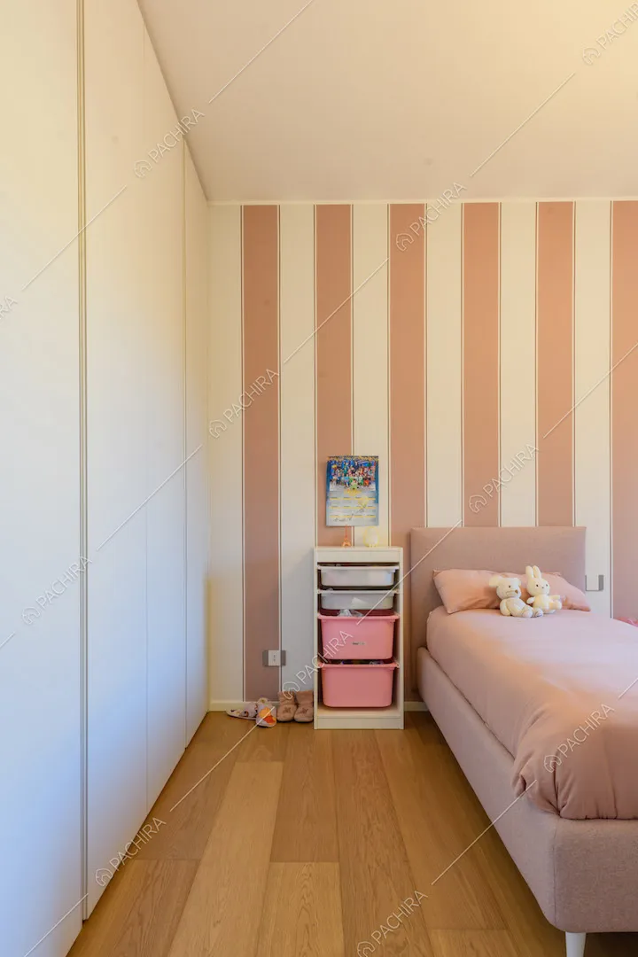 Pavimento in parquet nella camera con letti rosa e carta da parati