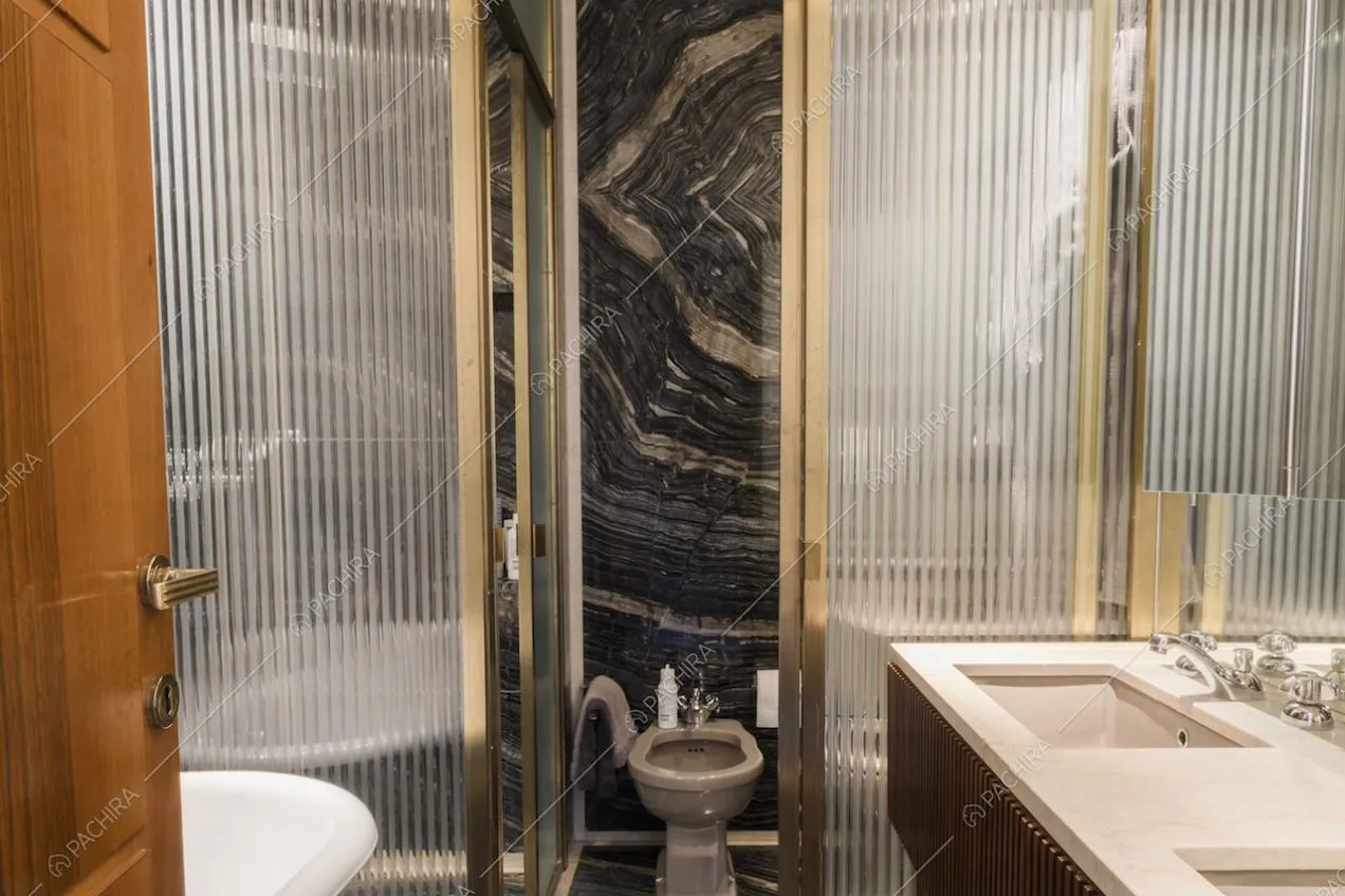 Bagno con vetrate e pareti in marmo