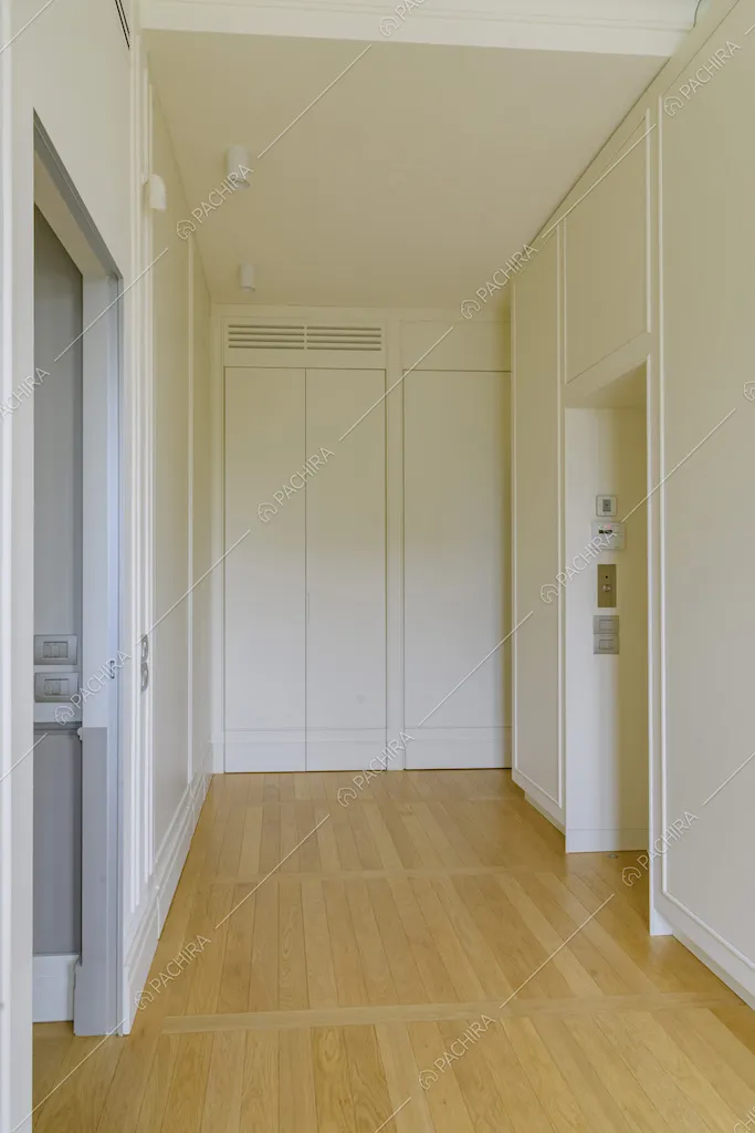 Ampio e luminoso corridoio dalle pareti bianche e dal pavimento in parquet