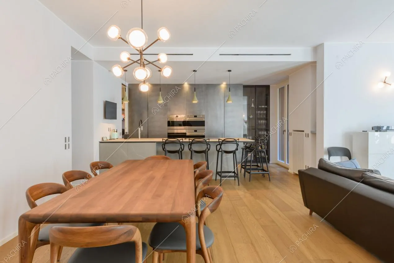 Tavolo da pranzo in legno da otto persone, pavimento in parquet e vista sulla cucina