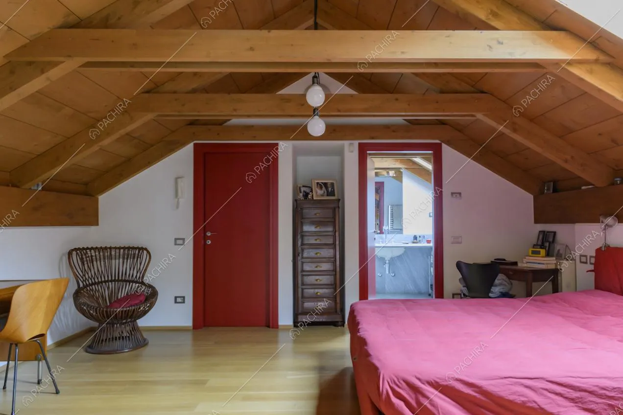 Camera da letto con travi in legno a vista, pavimento in parquet e bagno privato