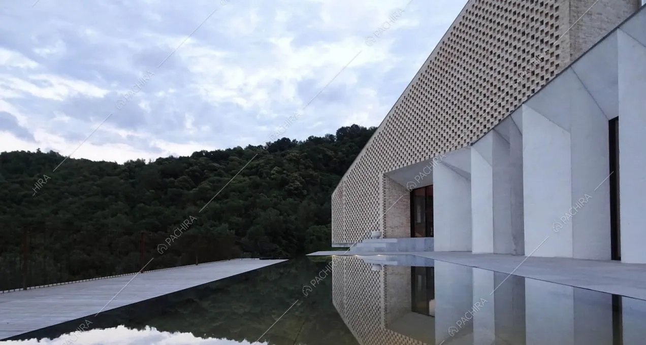 Piscina sulla terrazza della villa con vista sul parco, vetrate ed esterni bianchi e in mattoni rossi