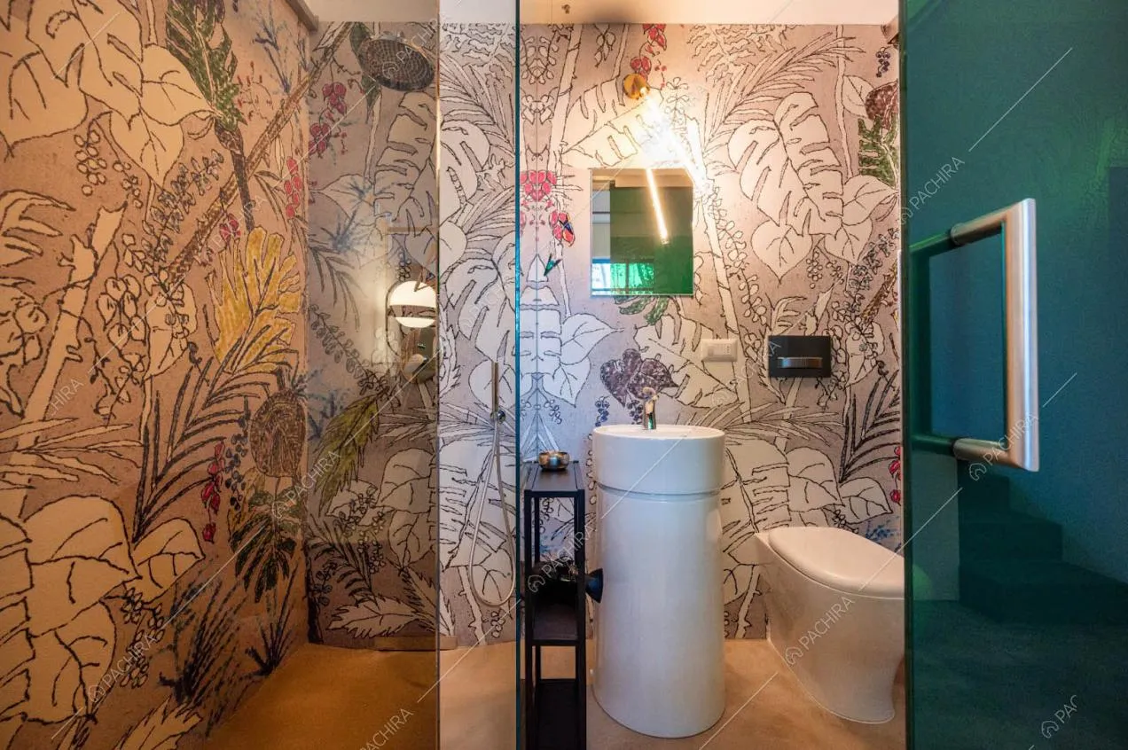 Carta da parati con fantasia tropicale nel bagno con pavimento in resina
