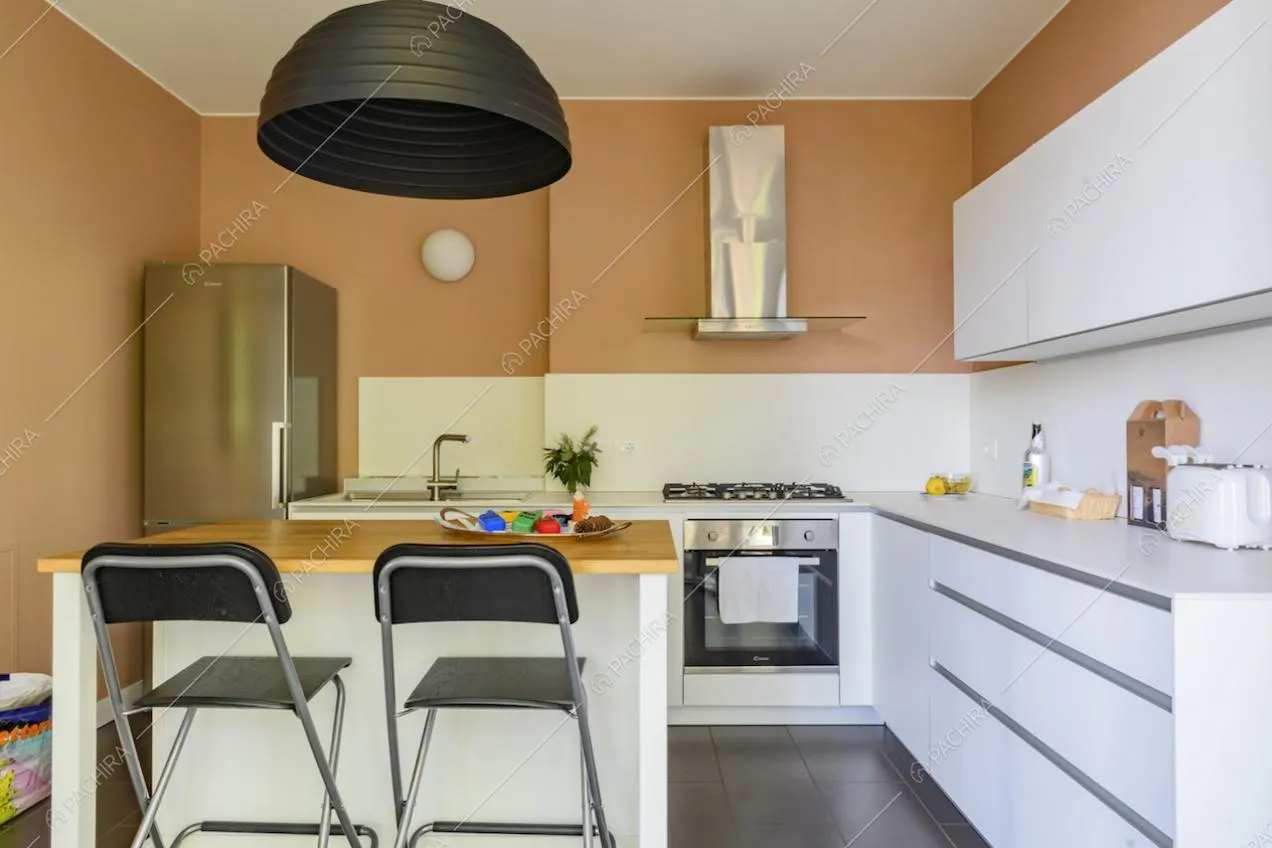 Cucina bianca a muro con fornelli a gas e bancone