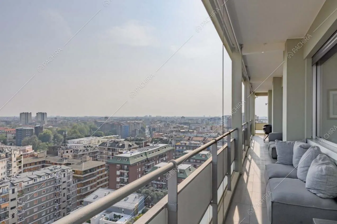 Terrazza con vista sullo skyline e pouf grigio