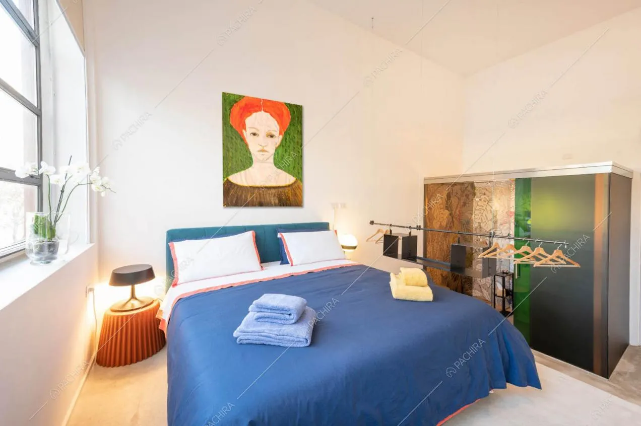 Camera da letto matrimoniale con finestre in stile industriale e pareti bianche