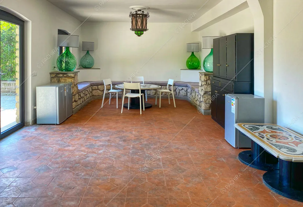 Stanza con pareti e soffitto bianchi, tavolo da pranzo e vetrata