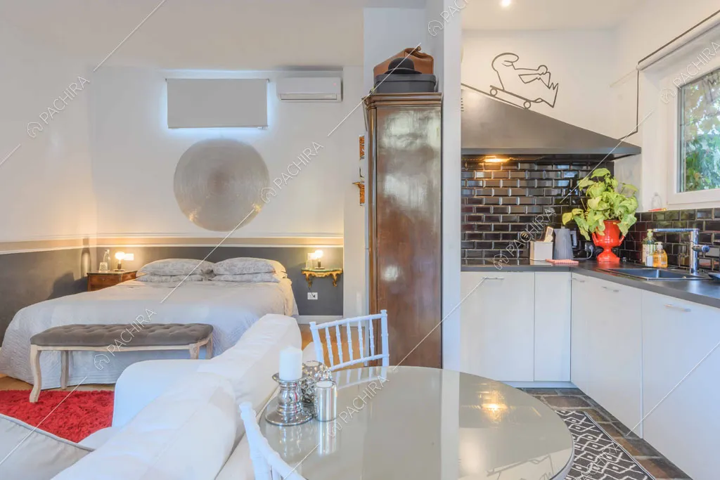 Camera da letto matrimoniale con cucina a parete dai mattoncini neri a vista