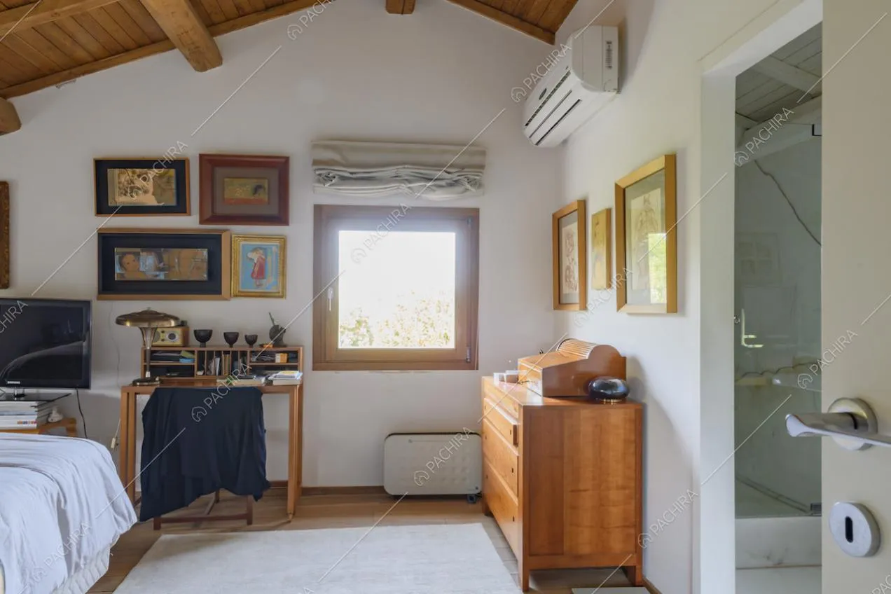 Camera da letto con travi a vista sul soffitto in legno