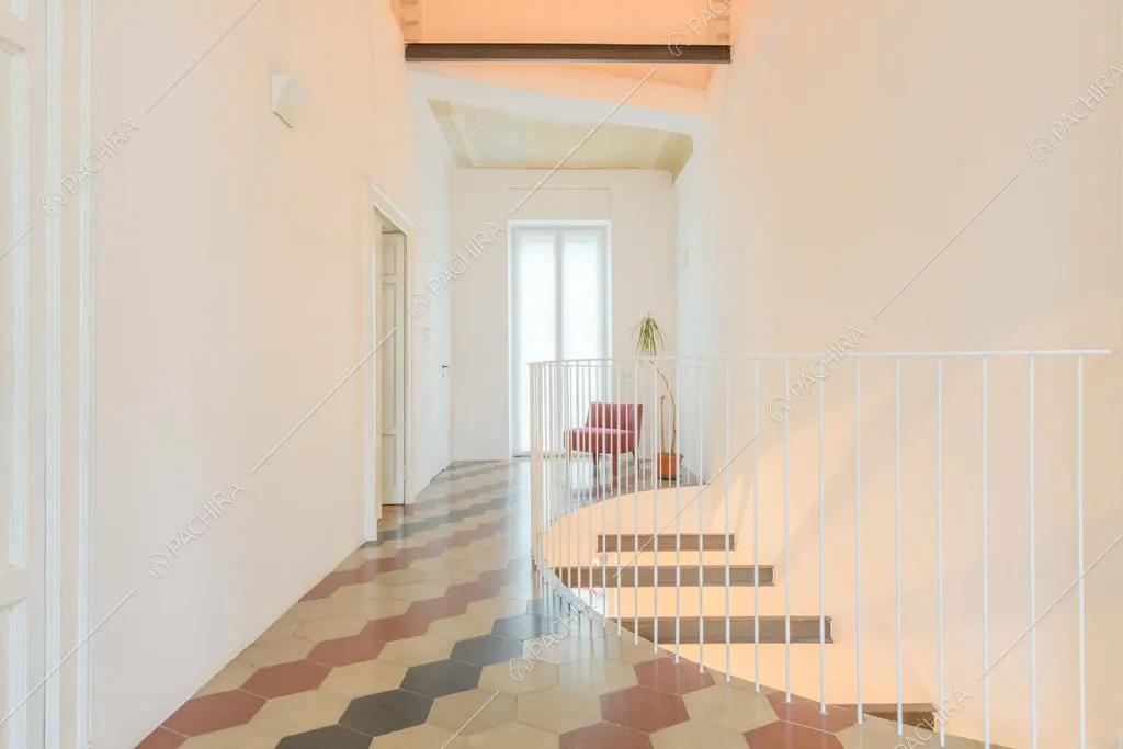 Pavimento in cementine colorate e pareti bianche al primo piano della villa