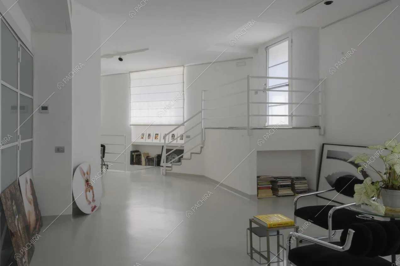 Soppalco con ringhiera bianca e arredi minimal