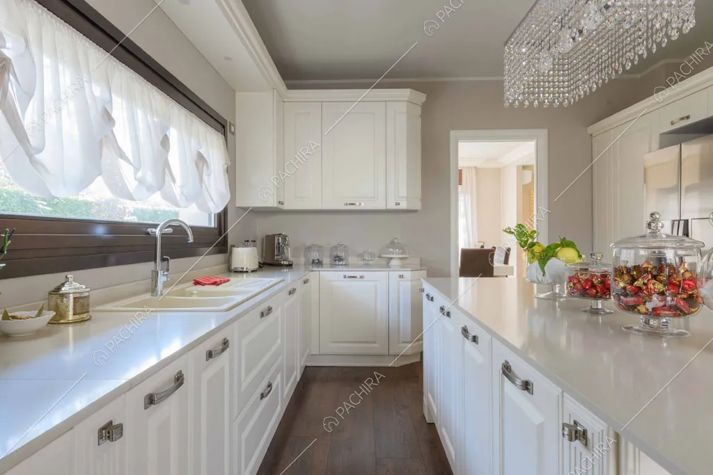 Cucina bianca a isola con boiserie, pavimento in parquet e tende a palloncino