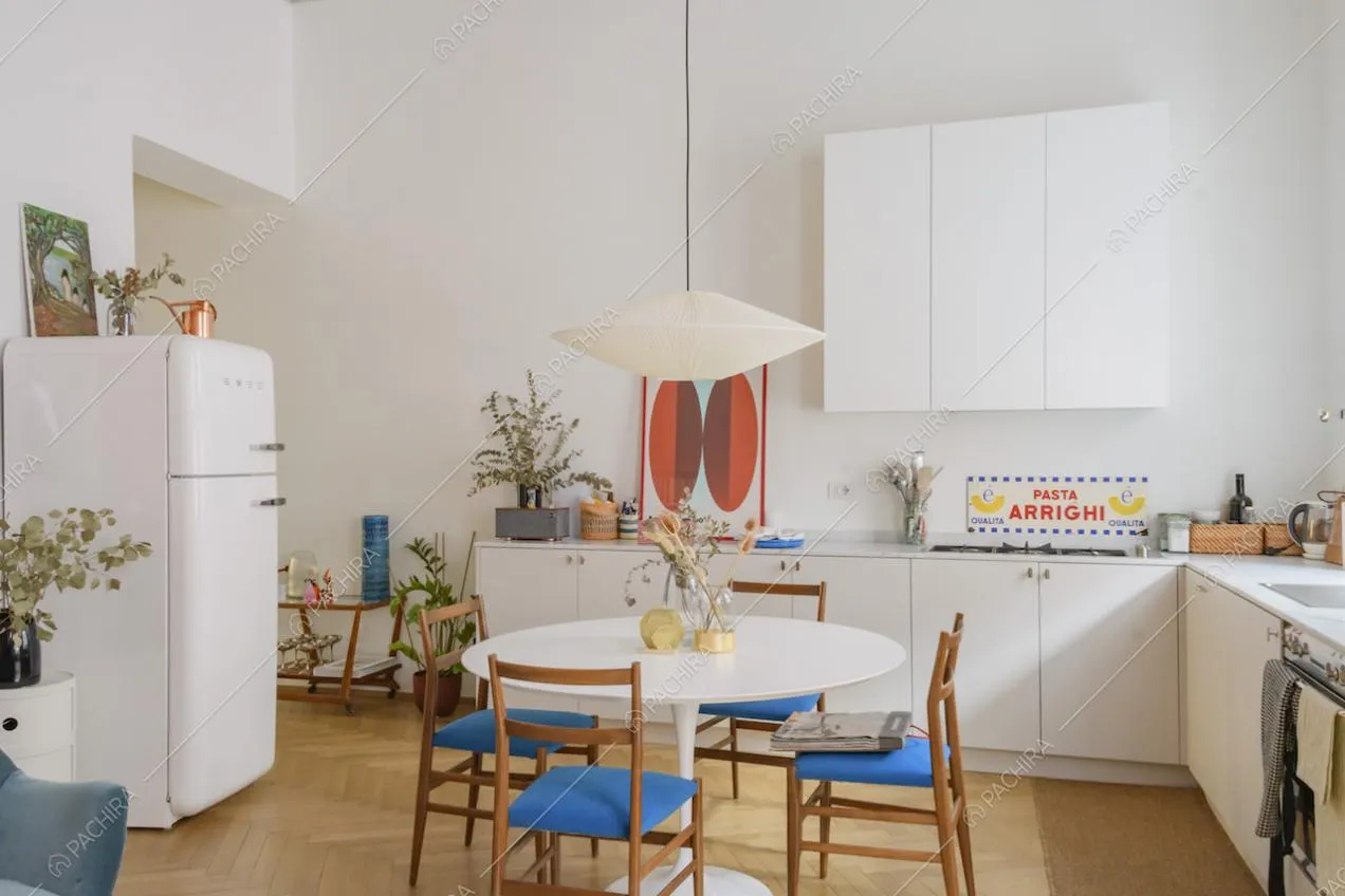 Cucina a muro dalle pareti bianche e parquet a spina di pesce