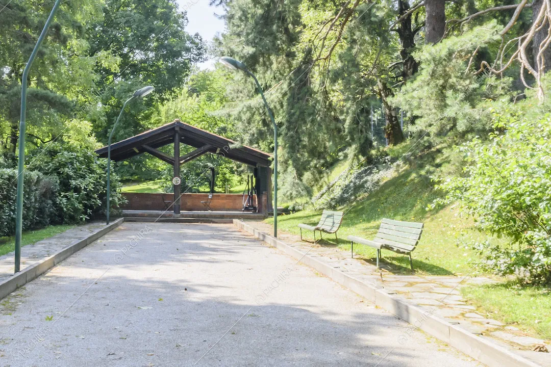 Struttura con tettoia e panchine nel giardino della villa