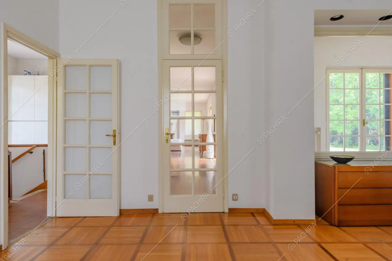 Pavimento in parquet nel corridoio con porte a vetri bianche