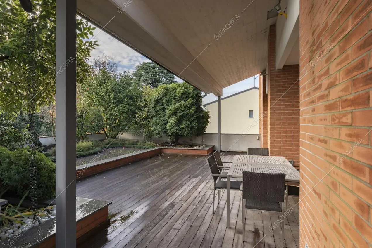 Veranda con tettoia, pavimento in legno e vista sul giardino
