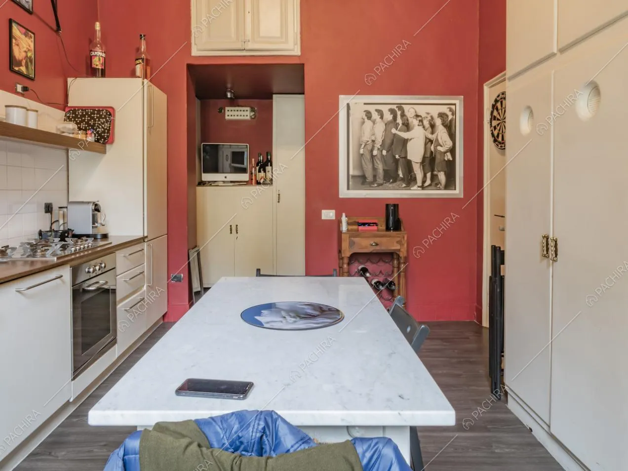 Tavolo da pranzo in marmo, pareti color rosso e portavini antico