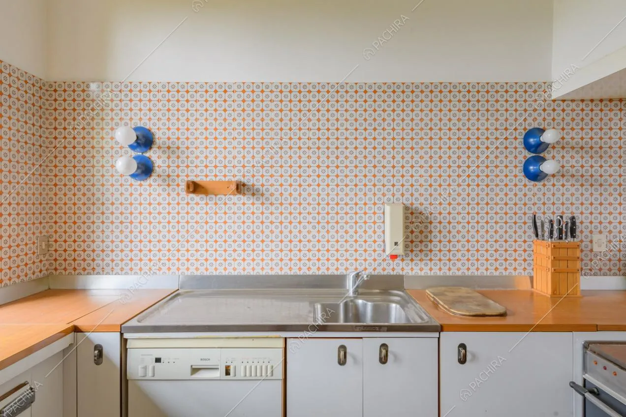 Parete in piastrelle colorate nella cucina con piano da lavoro in legno