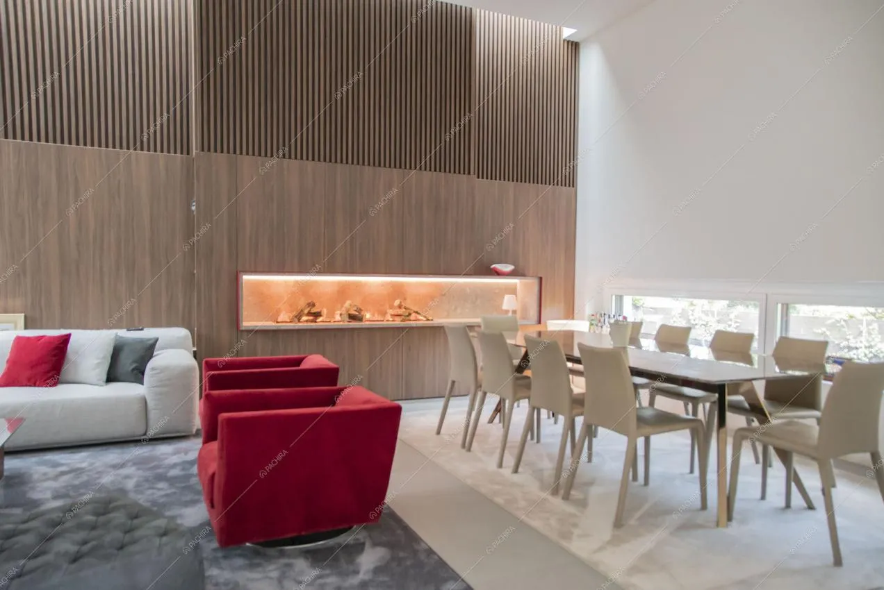 Tavolo da pranzo, poltrone rosse e divano bianco nella grande sala