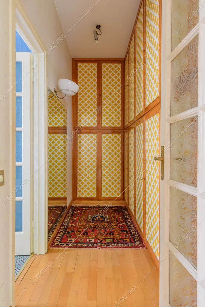 Armadi a muro colorati, pavimento in parquet e vista sul bagno